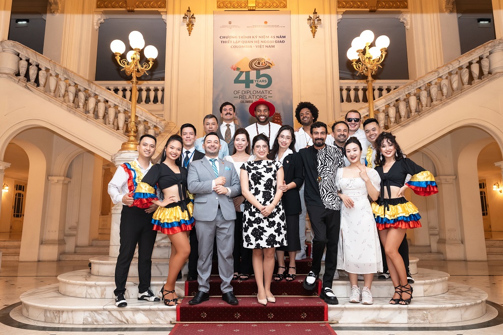 Foto grupal de los funcionarios de la Embajada de Colombia en Vietnam y los integrantes de la agrupación colombiana Salsangroove, en unas escaleras, durante la conmemoración de los 45 años de relaciones diplomáticas entre Colombia y Vietnam