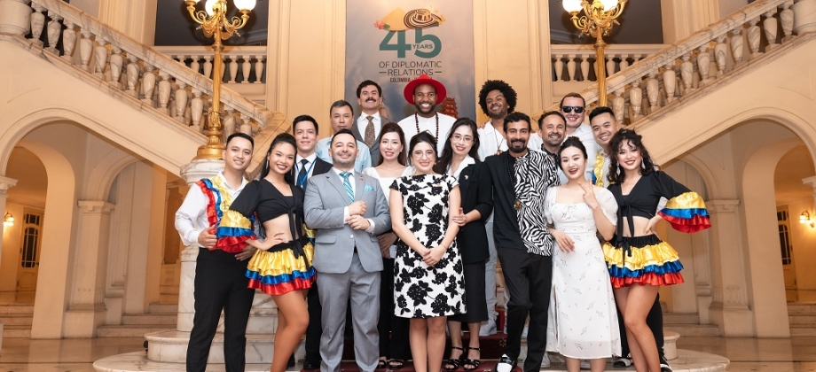 Foto grupal de los funcionarios de la Embajada de Colombia en Vietnam y los integrantes de la agrupación colombiana Salsangroove, en unas escaleras, durante la conmemoración de los 45 años de relaciones diplomáticas entre Colombia y Vietnam